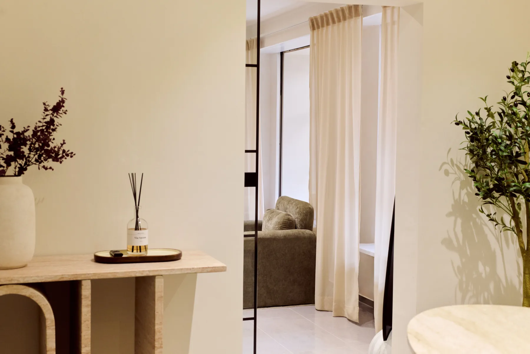Cosmetics Studio Munich: travertine console and linen curtains at the entrance to the studio